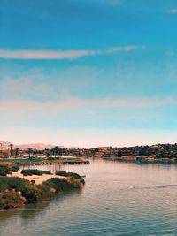 Scenic view of sea by buildings against sky