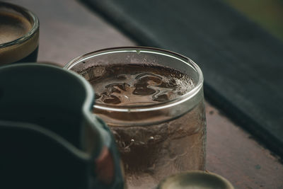 Extreme close up of the rim of a transparent glass cup of cool water.