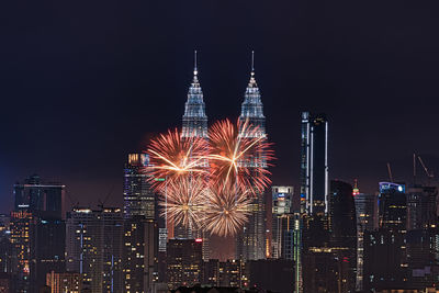 Firework display over city lit up at night