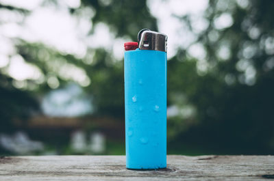 Close-up of blue pipe against trees