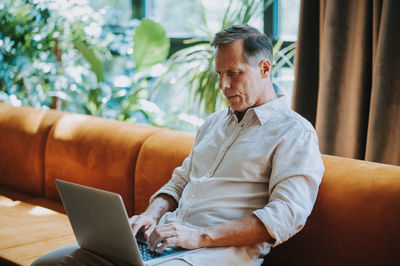 Young businesswoman using laptop while sitting at home