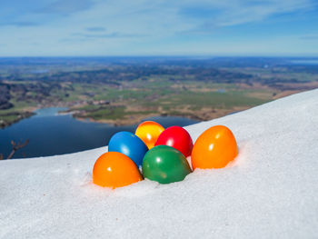 Close-up of multi colored stones on land against sea