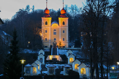 Illuminated buildings against sky at dusk