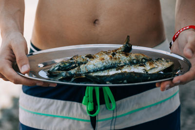 Midsection of man holding fish