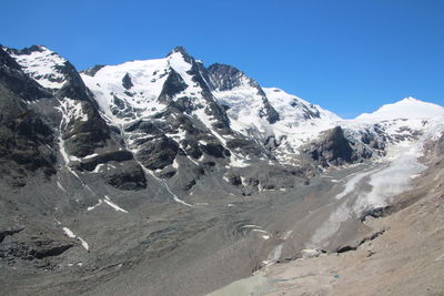 Scenic view of snowcapped mountains against clear blue sky