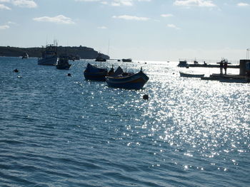 Sailboats moored on sea against sky