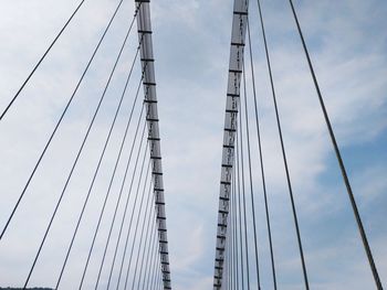 Low angle view of suspension bridge against sky