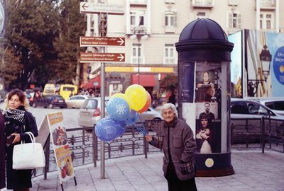 View of two men with balloons in city