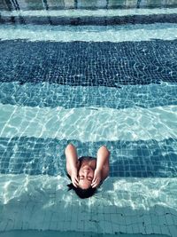 High angle view of woman relaxing in swimming pool