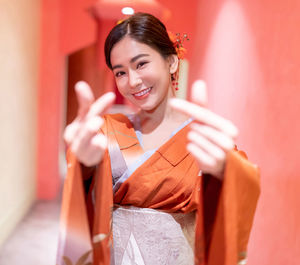 Portrait of smiling young woman standing at home