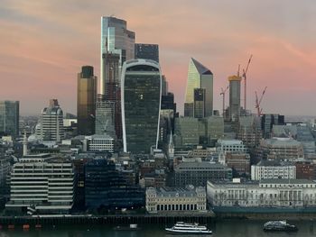 Buildings in city against sky during sunset