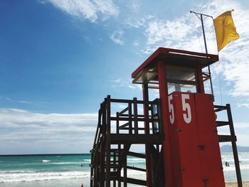 Lifeguard hut on beach against sky