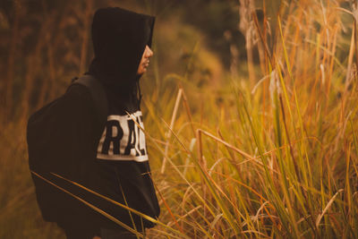 Side view of man standing by plants