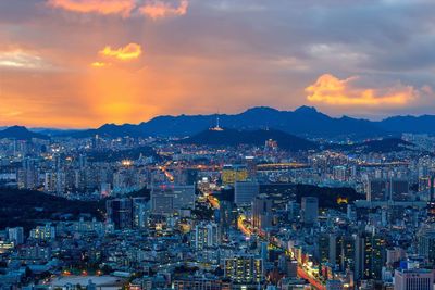 High angle view of city lit up at sunset