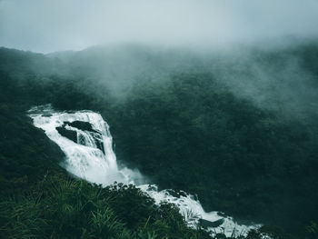 Scenic view of waterfall during foggy weather