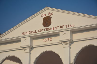 Low angle view of information sign against clear sky