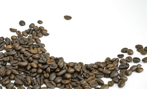 High angle view of coffee beans against white background
