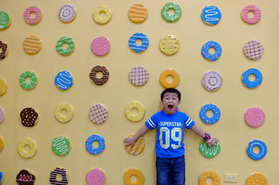 Portrait of boy standing against wall