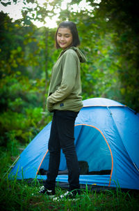 Full length of smiling woman standing on land