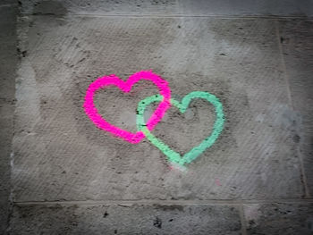 Close-up of heart shape on multi colored text