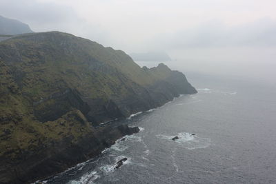 Scenic view of sea and mountains against sky