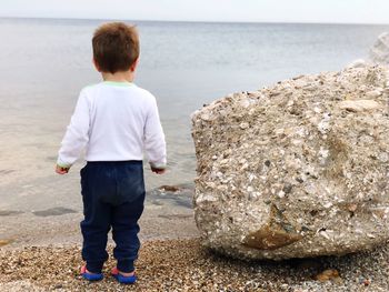 Rear view of boy standing on beach