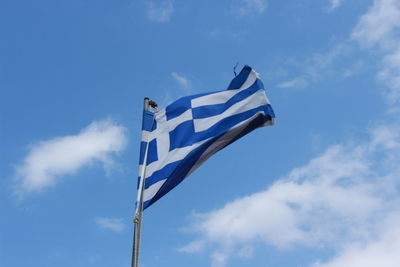 Low angle view of greek flag against blue sky