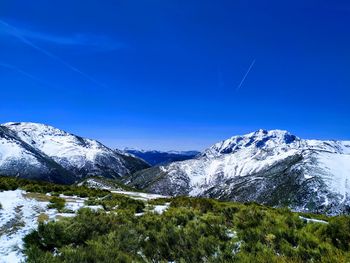 Scenic view of snowcapped mountains against clear blue sky