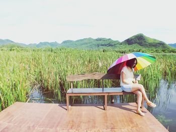 Rear view of woman sitting on bench
