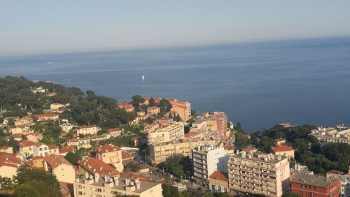 High angle view of townscape by sea against sky