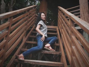 Portrait of woman sitting on wooden staircase