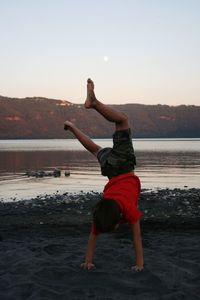 Full length of man standing on beach against clear sky