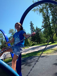 Full length of young woman against blue sky