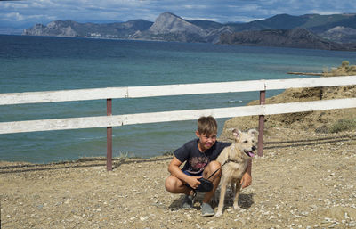 Boy with a dog on the background of the seascape. friendship of children with pets. traveling. 