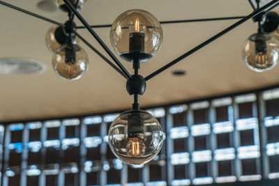 Low angle view of illuminated light bulb hanging from ceiling