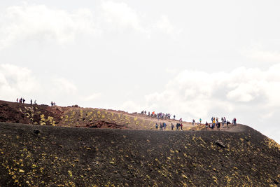 Group of people on land against sky