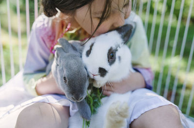 High angle view of girl playing with rabbits at yard