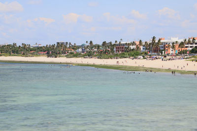 Panoramic view of people on beach against sky