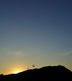 Scenic view of silhouette mountains against clear sky during sunset