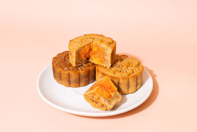 Close-up of cookies in plate on pink background