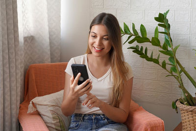 Beautiful woman using her cellphone at home. technology smartphone concept.