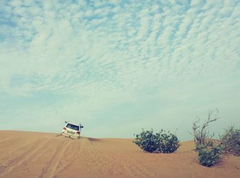 Car on desert against sky