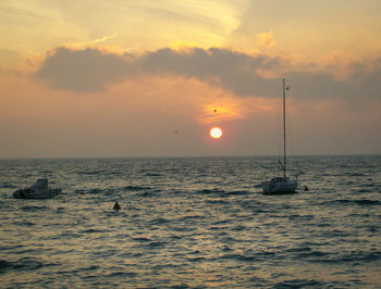 Sailboat on sea against sky during sunset