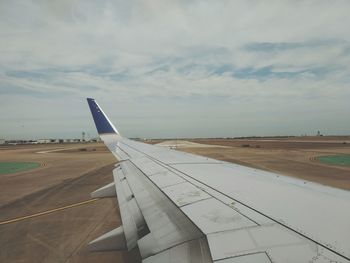 Airplane on airport runway against sky