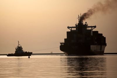 Silhouette ship on sea against sky during sunset