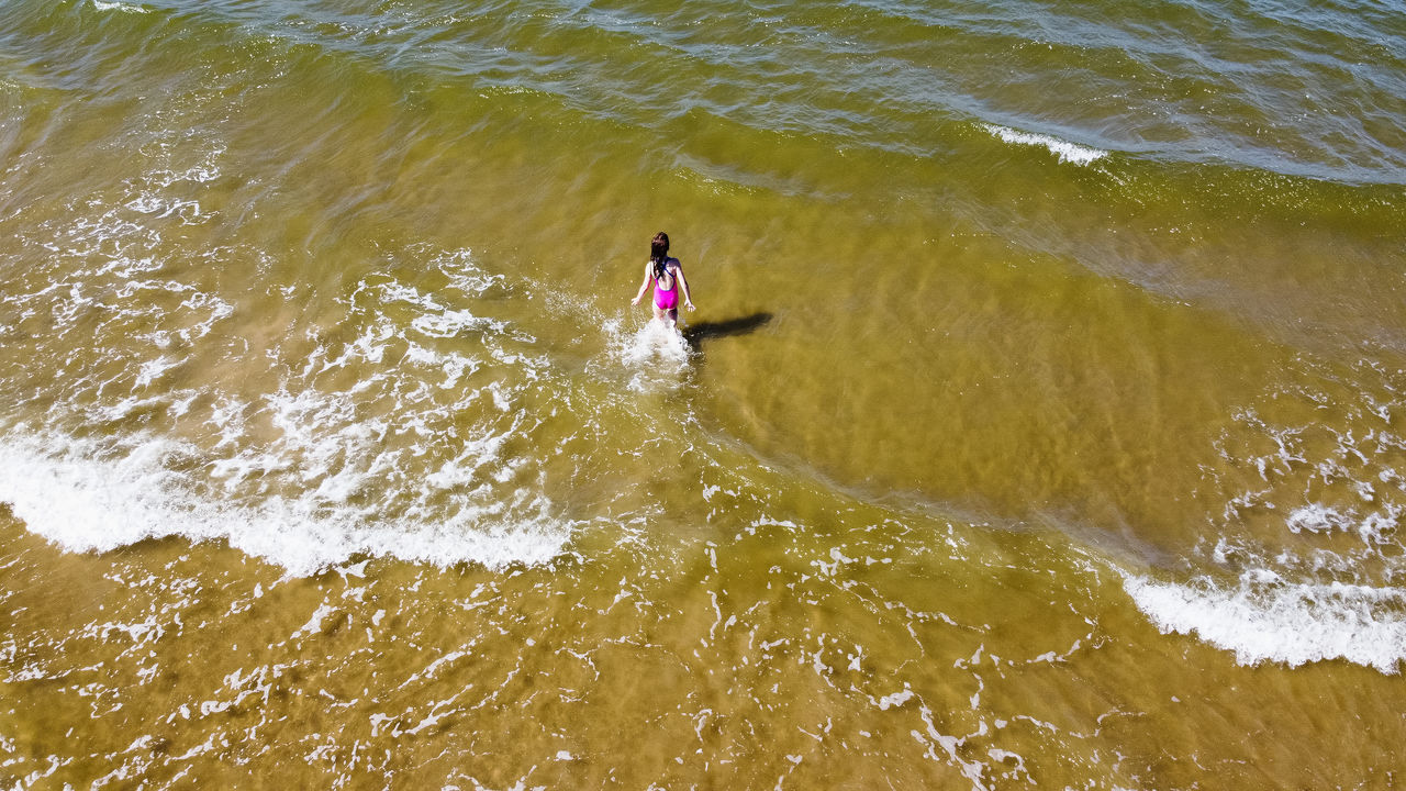 HIGH ANGLE VIEW OF WOMAN ON SEA