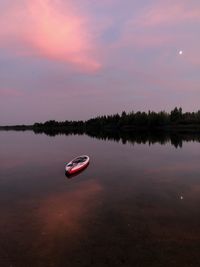 Boat in lake against sky during sunset