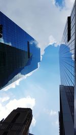 Low angle view of skyscrapers against blue sky