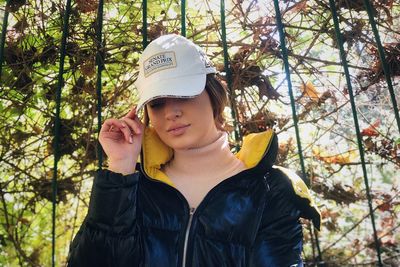 Portrait of young man standing against trees