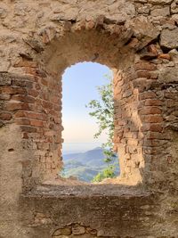 Arch window on wall against sky